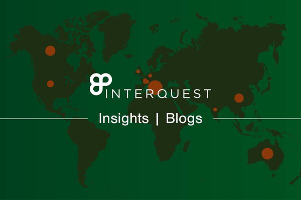 White InterQuest logo on a grey-filtered background graphic of a green world map