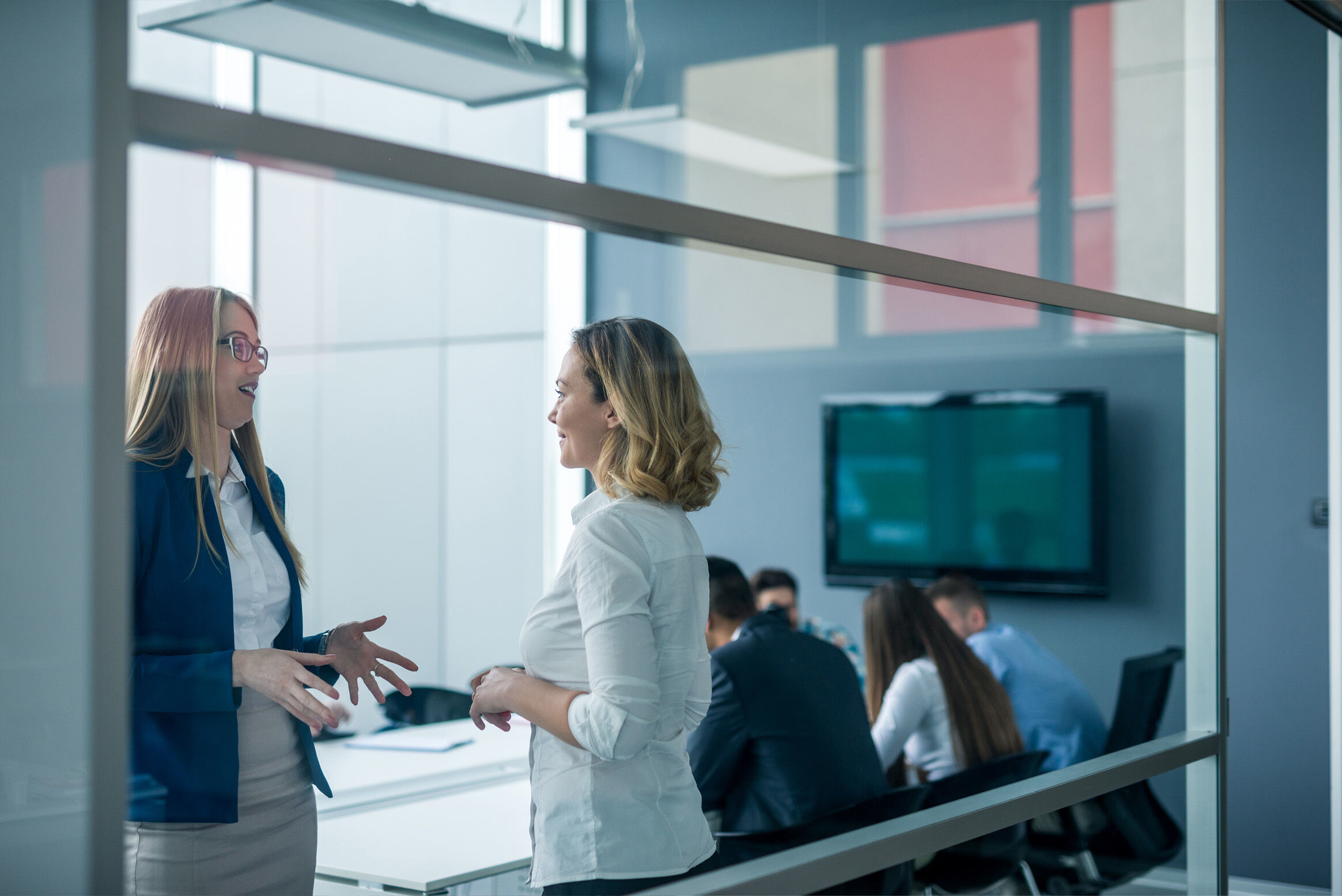 A meeting room in a contemporary office space with clear glass walls