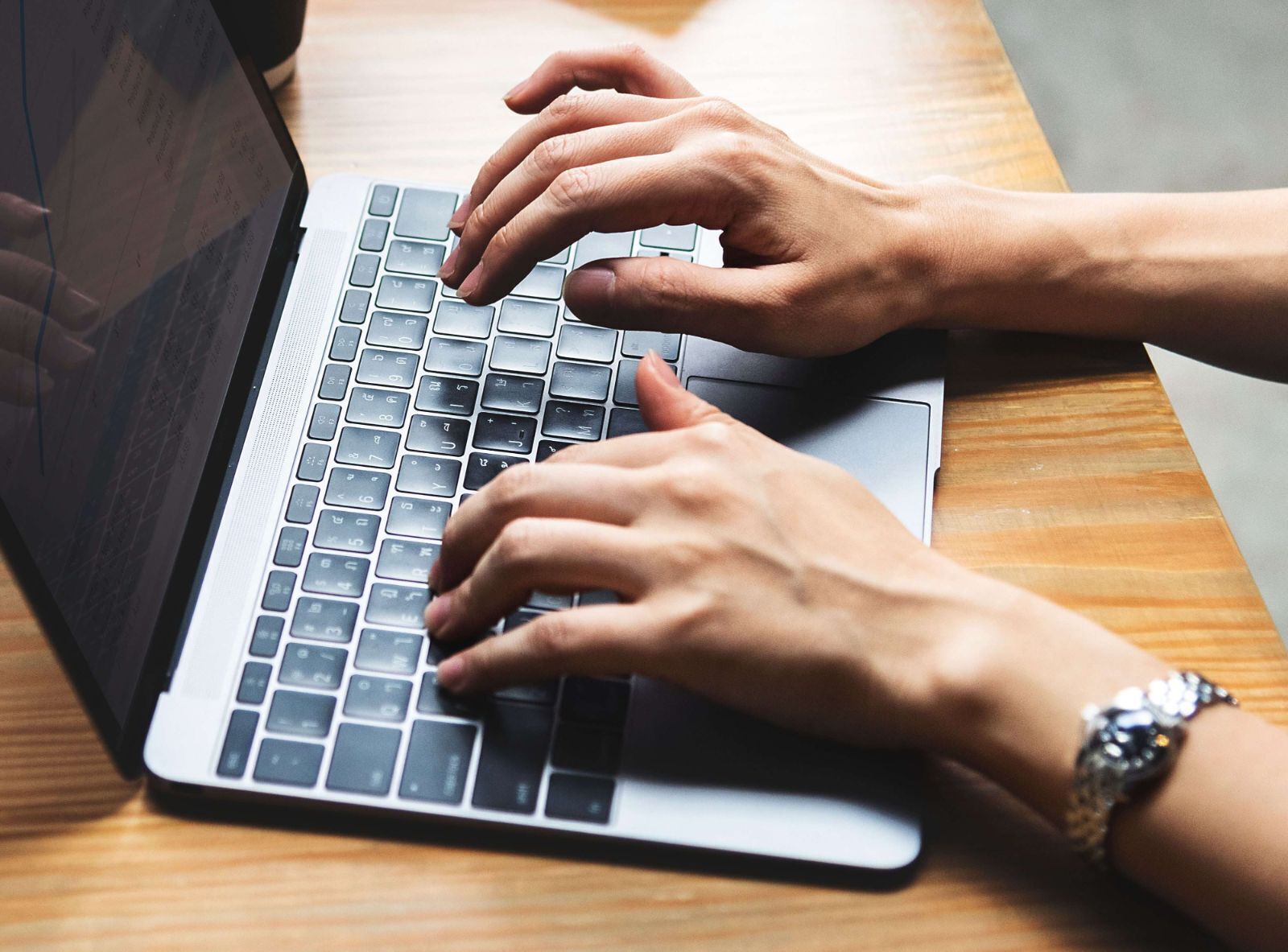 hands typing on a laptop keyboard