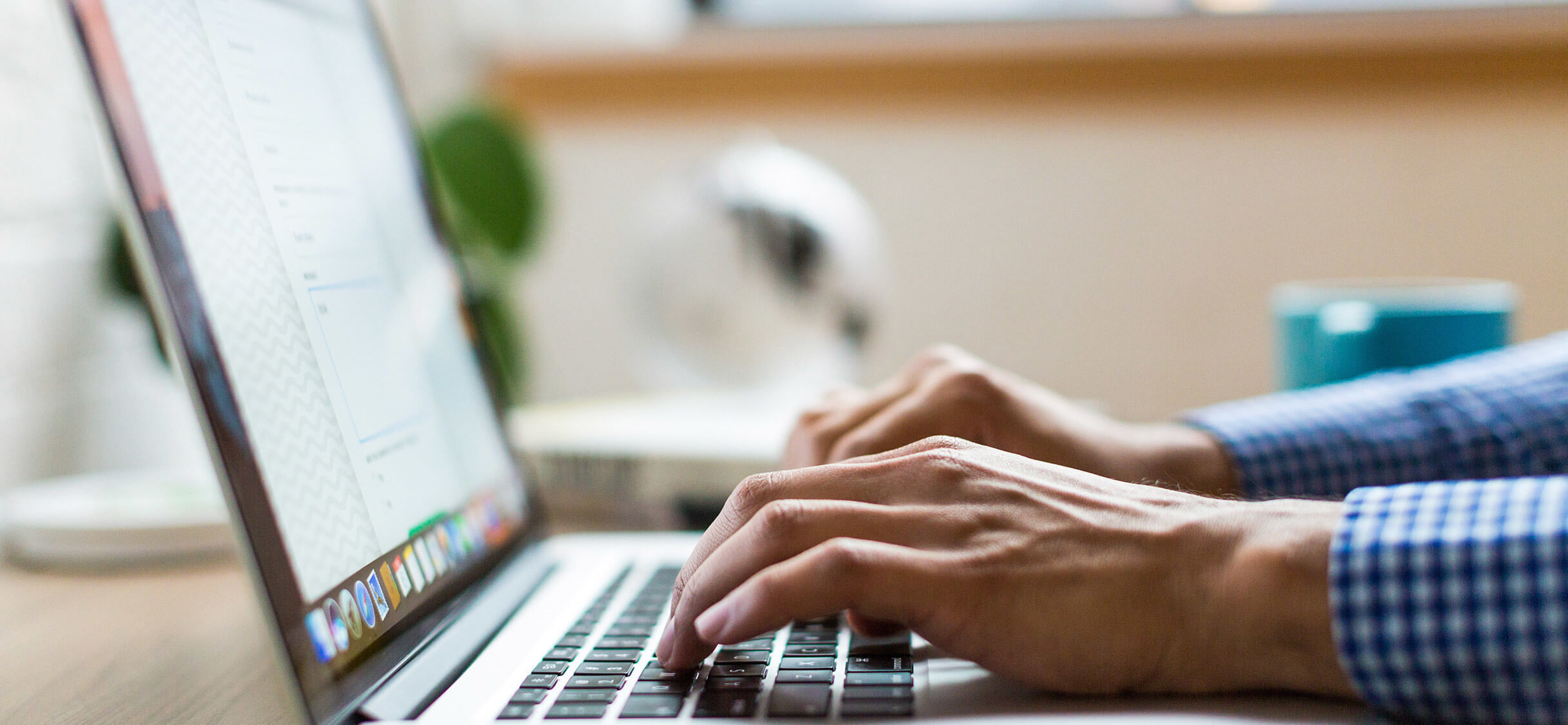 A pair of hands typing on a laptop keyboard