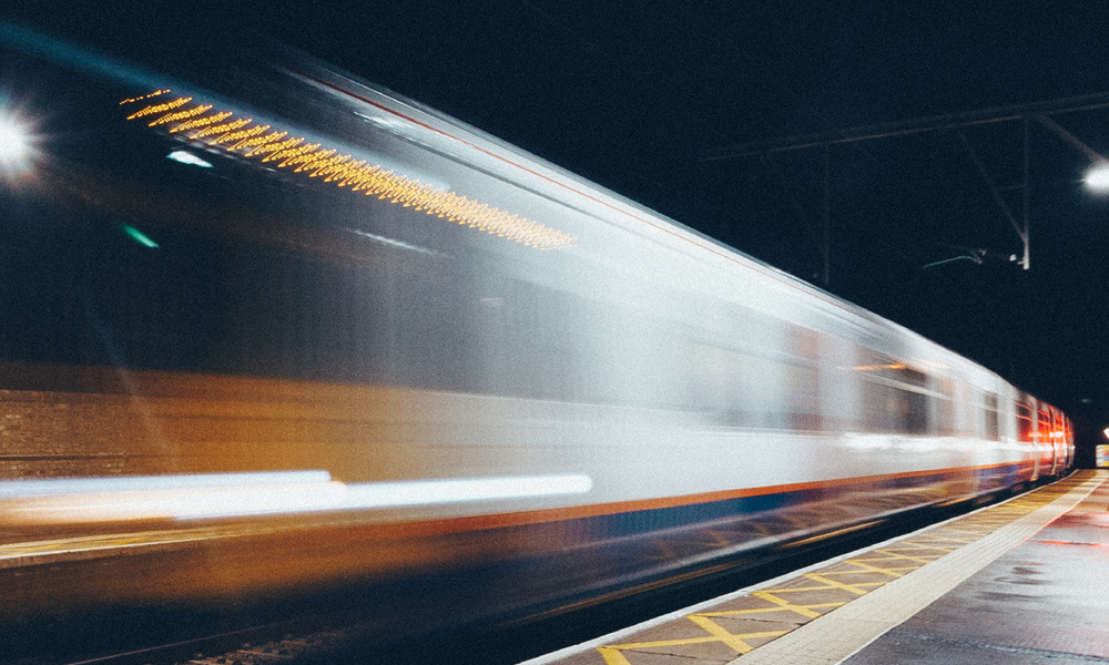 Photo of a train pulling out of a station with motion blur
